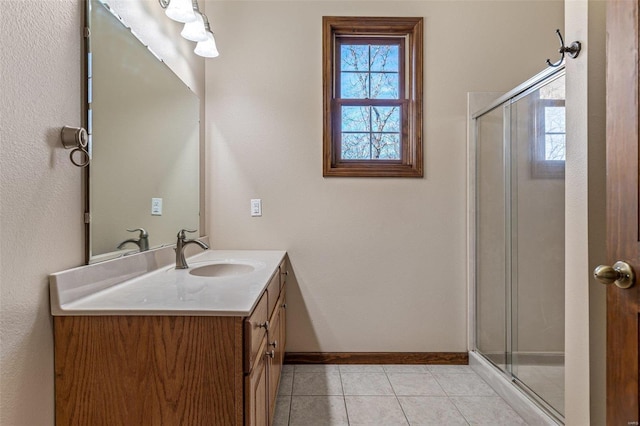 full bath with tile patterned flooring, a shower stall, vanity, and baseboards