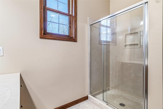 bathroom featuring tile patterned floors, a stall shower, and baseboards