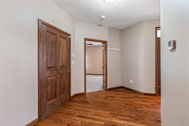 hallway with baseboards and wood finished floors