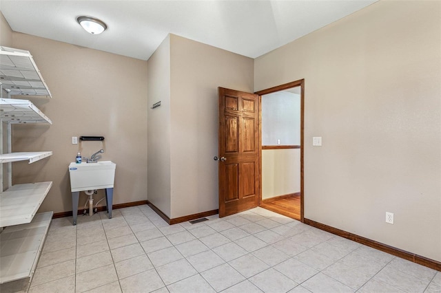 interior space with light tile patterned floors and baseboards