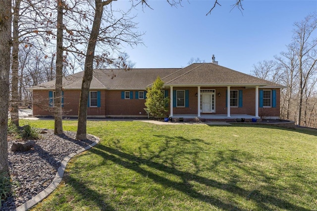 view of front of property featuring brick siding, a porch, a front yard, and a shingled roof