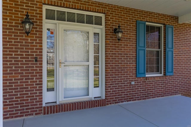 doorway to property featuring brick siding