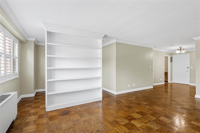 unfurnished living room featuring crown molding, baseboards, radiator heating unit, and a chandelier