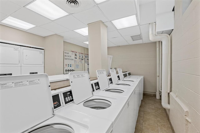 community laundry room featuring visible vents, independent washer and dryer, light tile patterned flooring, and concrete block wall