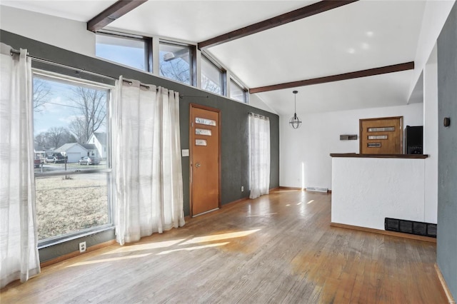 foyer featuring a notable chandelier, visible vents, vaulted ceiling with beams, and hardwood / wood-style flooring