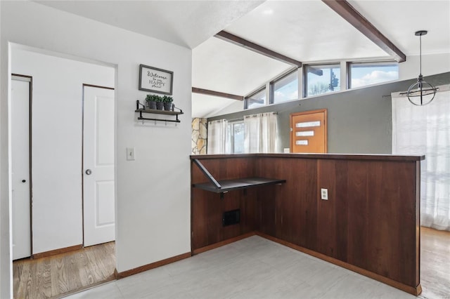 spare room with an inviting chandelier, lofted ceiling with beams, and baseboards