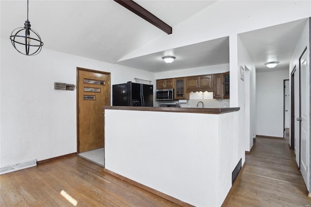 kitchen with stainless steel microwave, light wood-type flooring, visible vents, and black refrigerator with ice dispenser