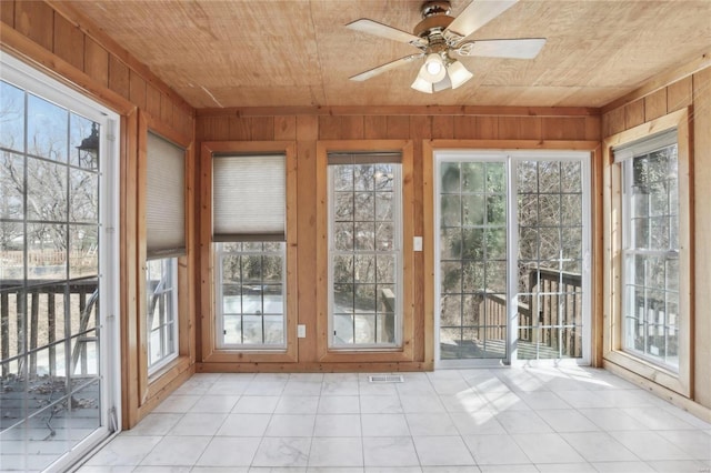 unfurnished sunroom featuring visible vents, wooden ceiling, and a ceiling fan