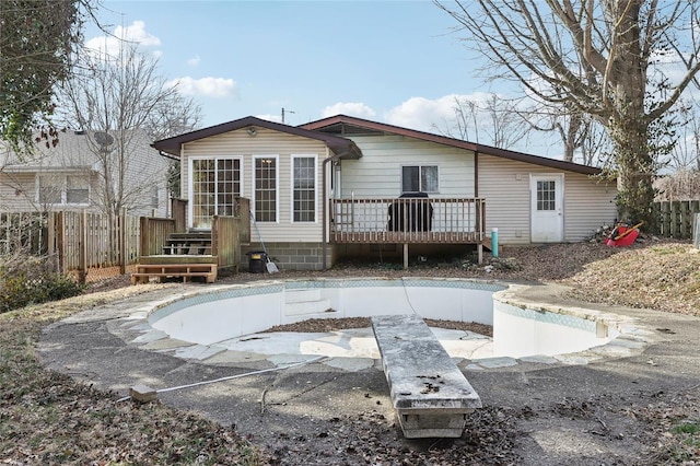 rear view of property with a deck and fence