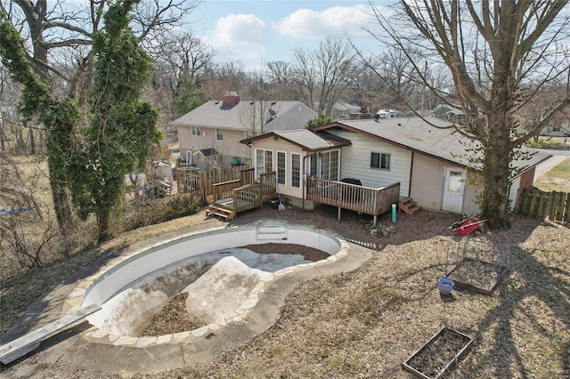 rear view of property featuring roof with shingles, a deck, and fence