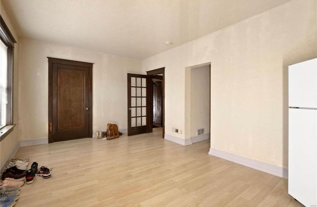 spare room with visible vents, baseboards, and light wood-style floors