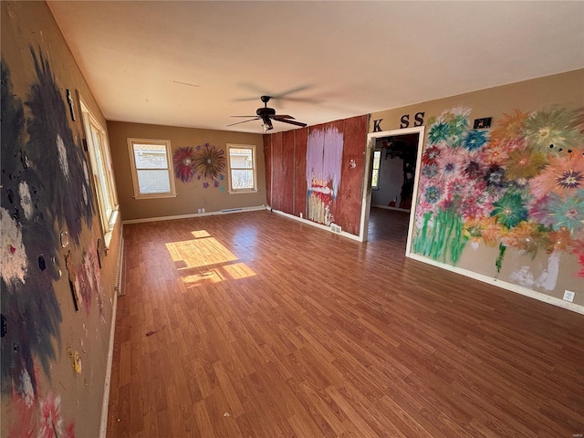 empty room with wood finished floors, baseboards, and ceiling fan