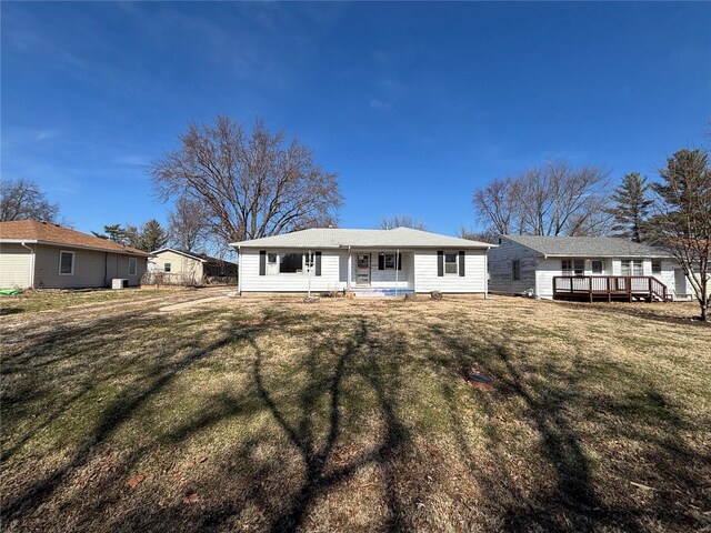 rear view of property with covered porch and a lawn