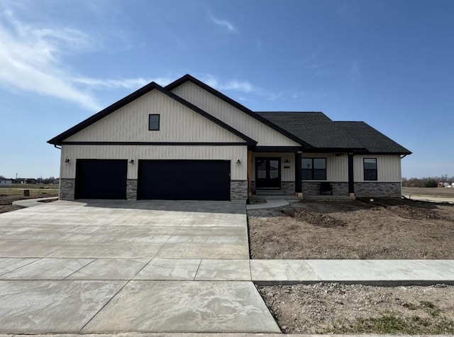 modern farmhouse with stone siding, driveway, an attached garage, and roof with shingles