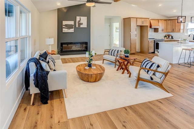 living room with recessed lighting, a ceiling fan, lofted ceiling, and light wood-style floors