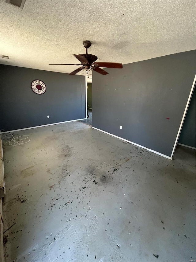 interior space featuring a textured ceiling, concrete flooring, and a ceiling fan