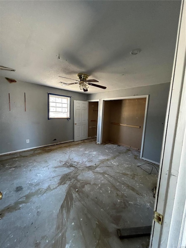 unfurnished bedroom with two closets and a ceiling fan