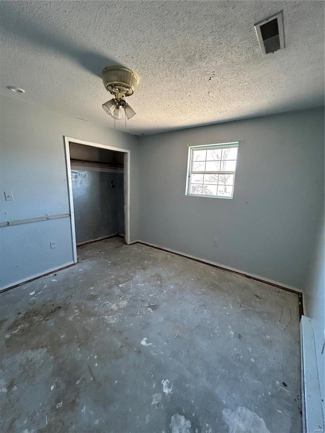 unfurnished bedroom featuring visible vents, a closet, and a textured ceiling