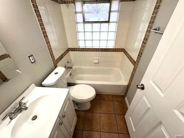 full bath with vanity, tile patterned floors, toilet, and  shower combination