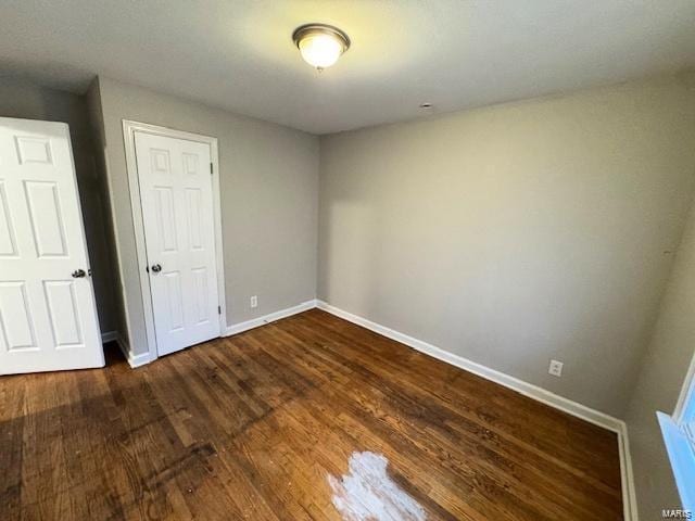 unfurnished room with baseboards and wood finished floors