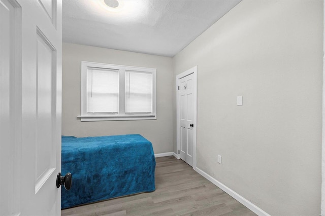 bedroom with baseboards and wood finished floors