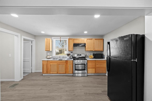 kitchen featuring black appliances, light countertops, visible vents, and under cabinet range hood