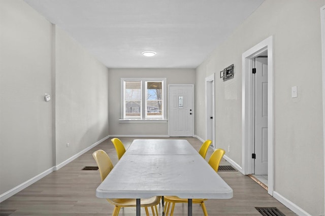 dining room with visible vents, baseboards, and light wood finished floors