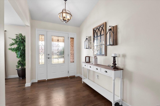 foyer entrance featuring a chandelier, baseboards, lofted ceiling, and dark wood-style flooring