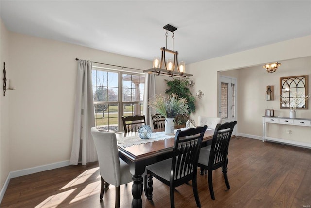 dining area featuring a chandelier, dark wood-style floors, and baseboards