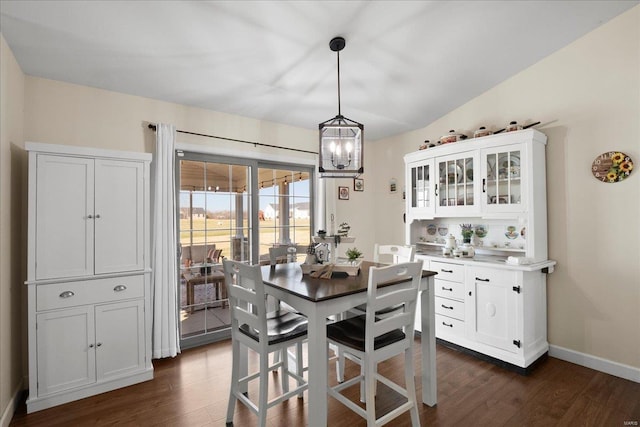 dining area with a notable chandelier, baseboards, and dark wood-style flooring