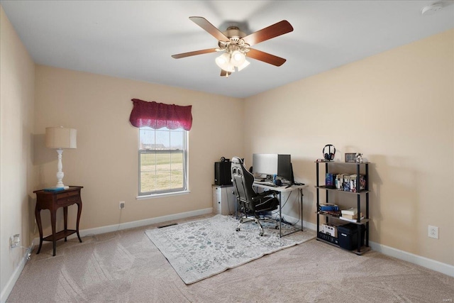 carpeted office space with baseboards and ceiling fan