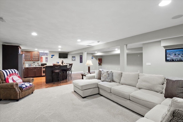 living area featuring visible vents, baseboards, light wood-type flooring, indoor wet bar, and recessed lighting