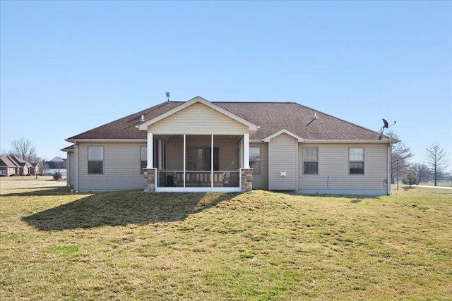 rear view of house with a yard and a sunroom