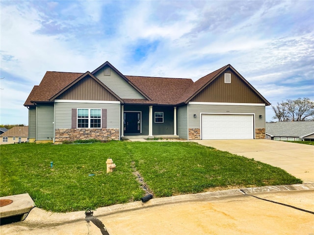 craftsman-style home featuring roof with shingles, driveway, stone siding, an attached garage, and a front lawn