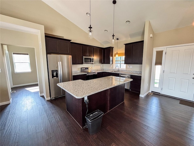kitchen featuring stainless steel appliances, dark wood-type flooring, dark brown cabinetry, and a center island