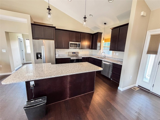 kitchen featuring a center island, a sink, dark wood-style flooring, appliances with stainless steel finishes, and dark brown cabinets