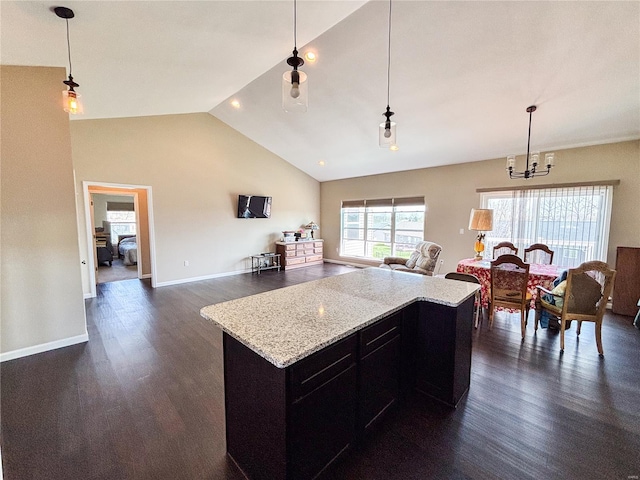 kitchen with dark wood-style flooring, open floor plan, decorative light fixtures, and dark cabinetry