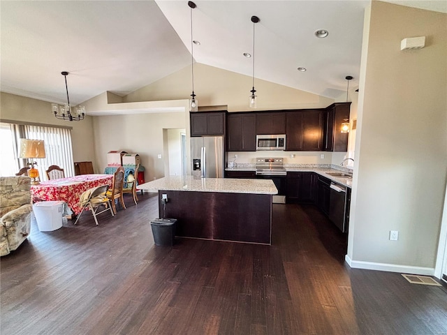 kitchen featuring dark brown cabinetry, dark wood-style flooring, an inviting chandelier, a kitchen island, and appliances with stainless steel finishes