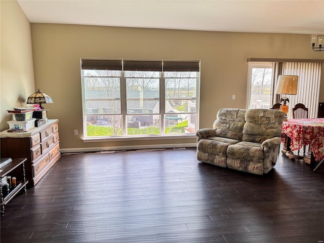 living room featuring a notable chandelier and dark wood-style flooring