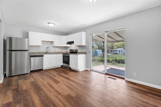 kitchen with dark wood-style floors, a sink, baseboards, visible vents, and appliances with stainless steel finishes