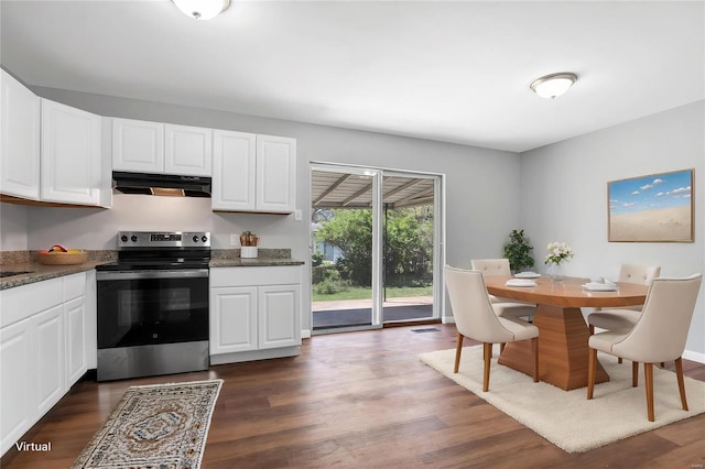 kitchen featuring dark wood-type flooring, stainless steel range with electric stovetop, under cabinet range hood, and white cabinets
