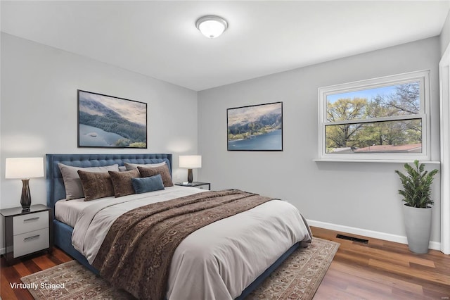 bedroom with dark wood-style floors, baseboards, and visible vents