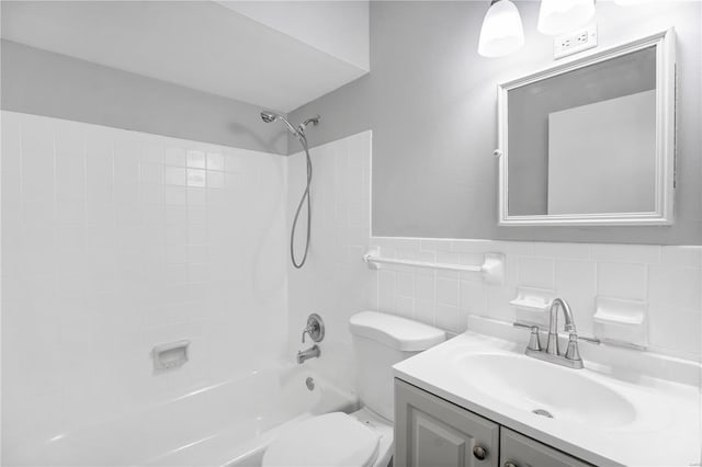 bathroom featuring shower / bathing tub combination, wainscoting, vanity, tile walls, and toilet