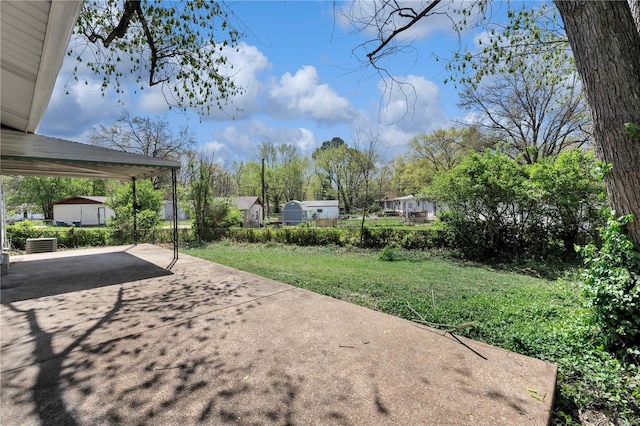 view of yard featuring fence, a patio, and driveway