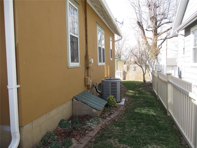 exterior space featuring central air condition unit and fence