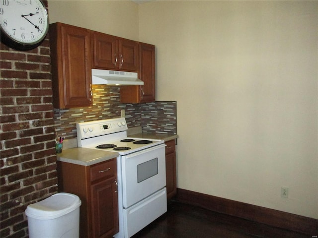 kitchen featuring white electric range oven, baseboards, decorative backsplash, light countertops, and under cabinet range hood