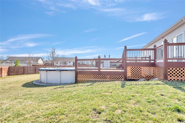 view of yard with a fenced in pool, a wooden deck, and fence