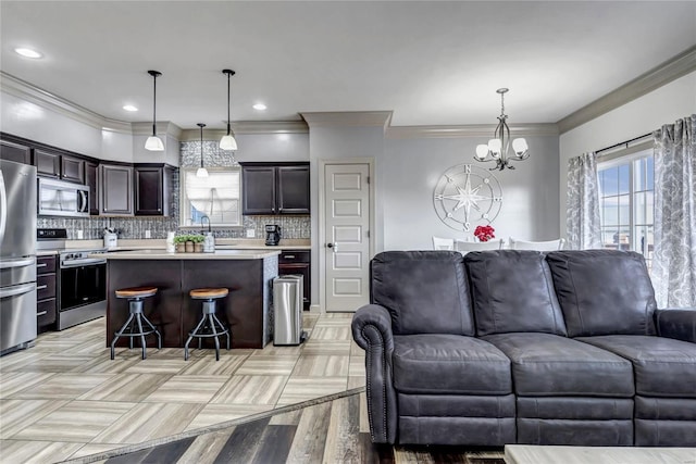 kitchen featuring a kitchen bar, open floor plan, an inviting chandelier, appliances with stainless steel finishes, and light countertops