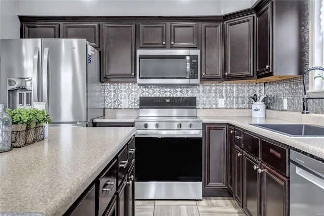 kitchen with tasteful backsplash, dark brown cabinetry, stainless steel appliances, and a sink