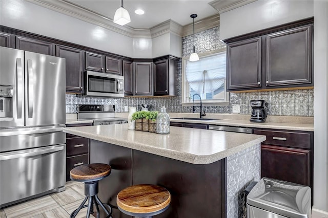 kitchen featuring a sink, backsplash, a center island, stainless steel appliances, and light countertops